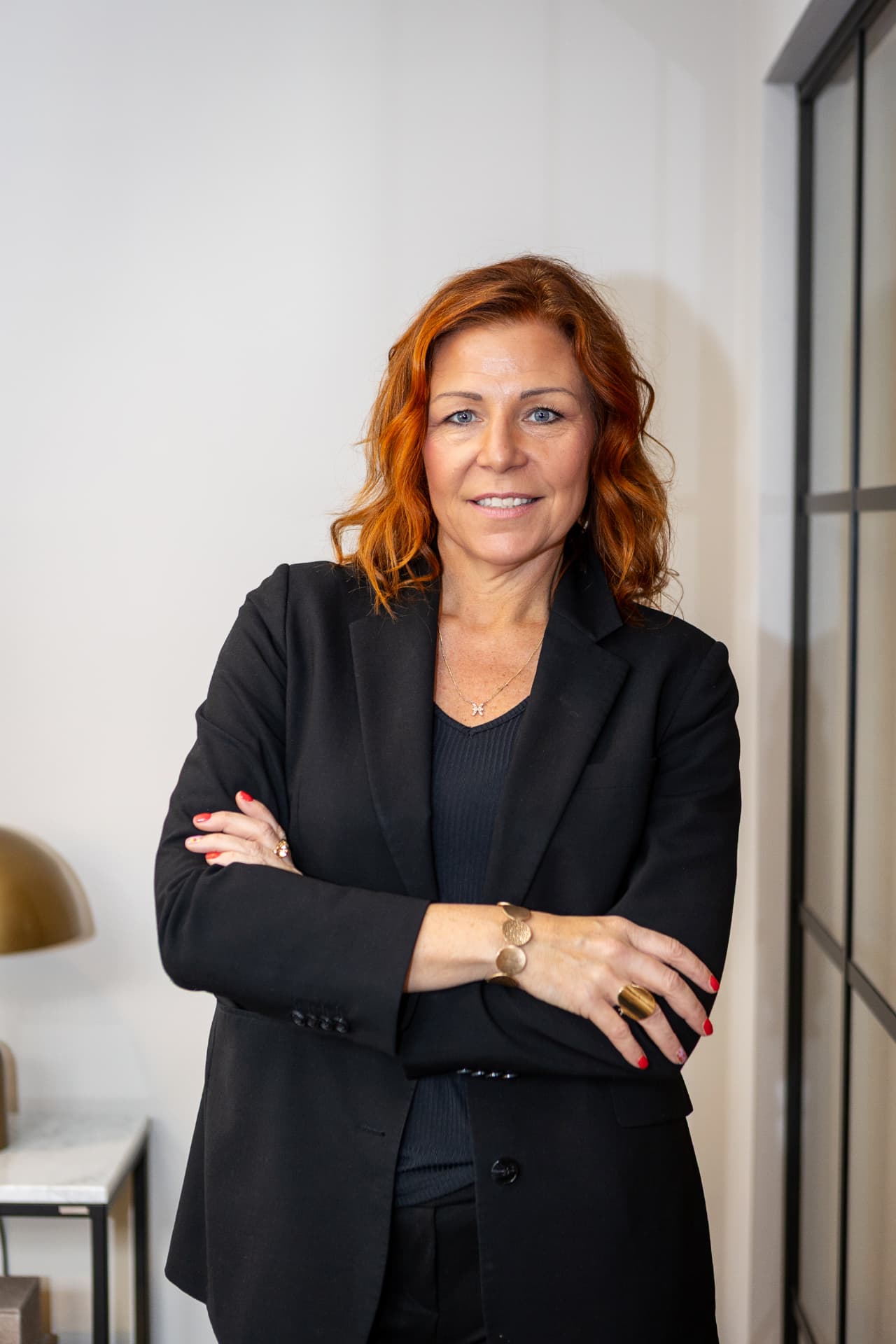 Sandra Sundbäck i svart kavaj vid ett fönster